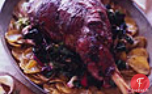 Gigot D'Agneau Rôti Sur Un Lit De Pommes De Terre Et De Légumes Verts Flétris